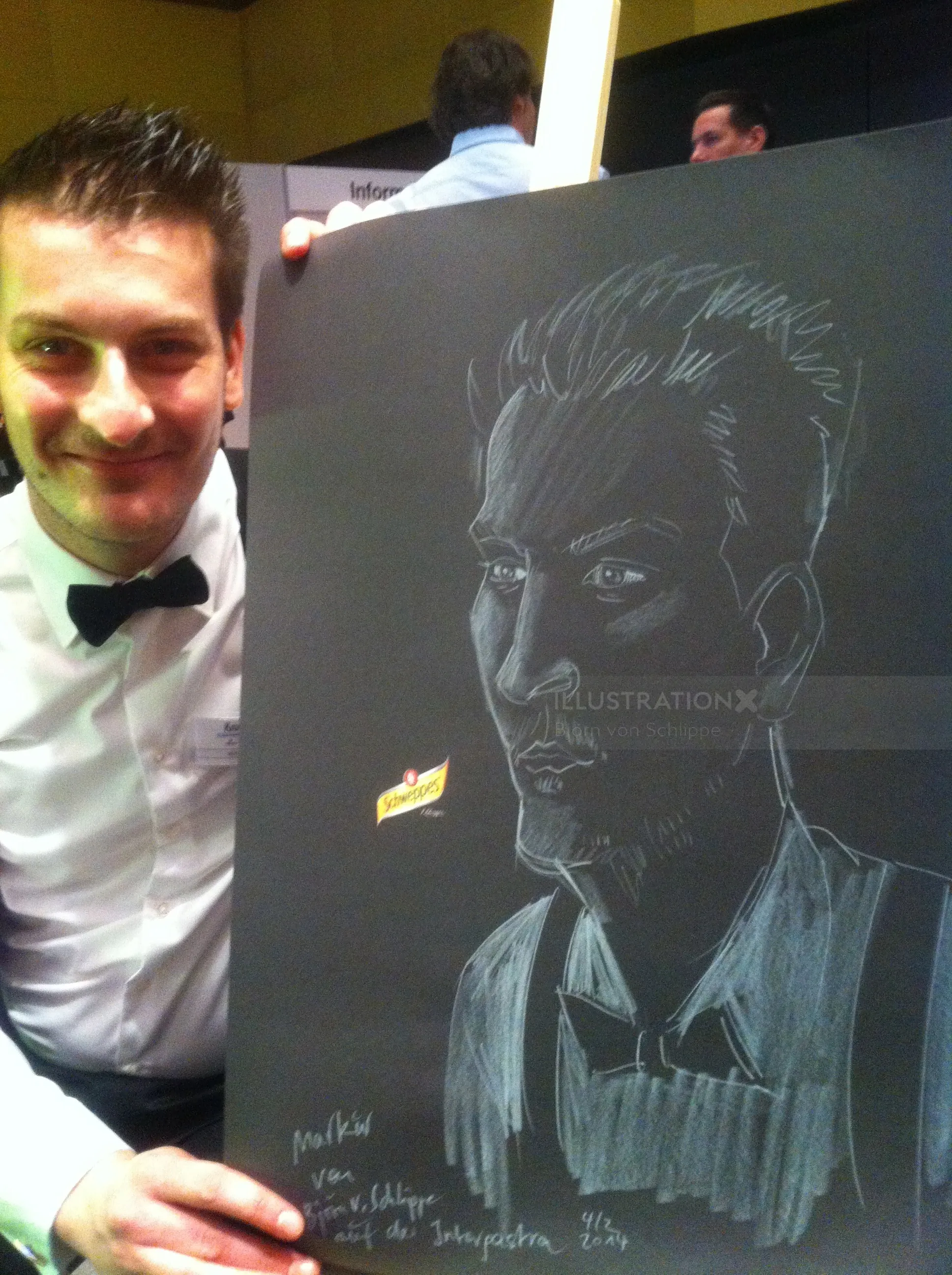 Man in tuxedo holds chalk portrait drawing on blackboard by Björn von Schlippe