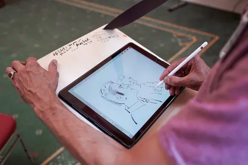 Person drawing a digital portrait on tablet with stylus by Björn von Schlippe