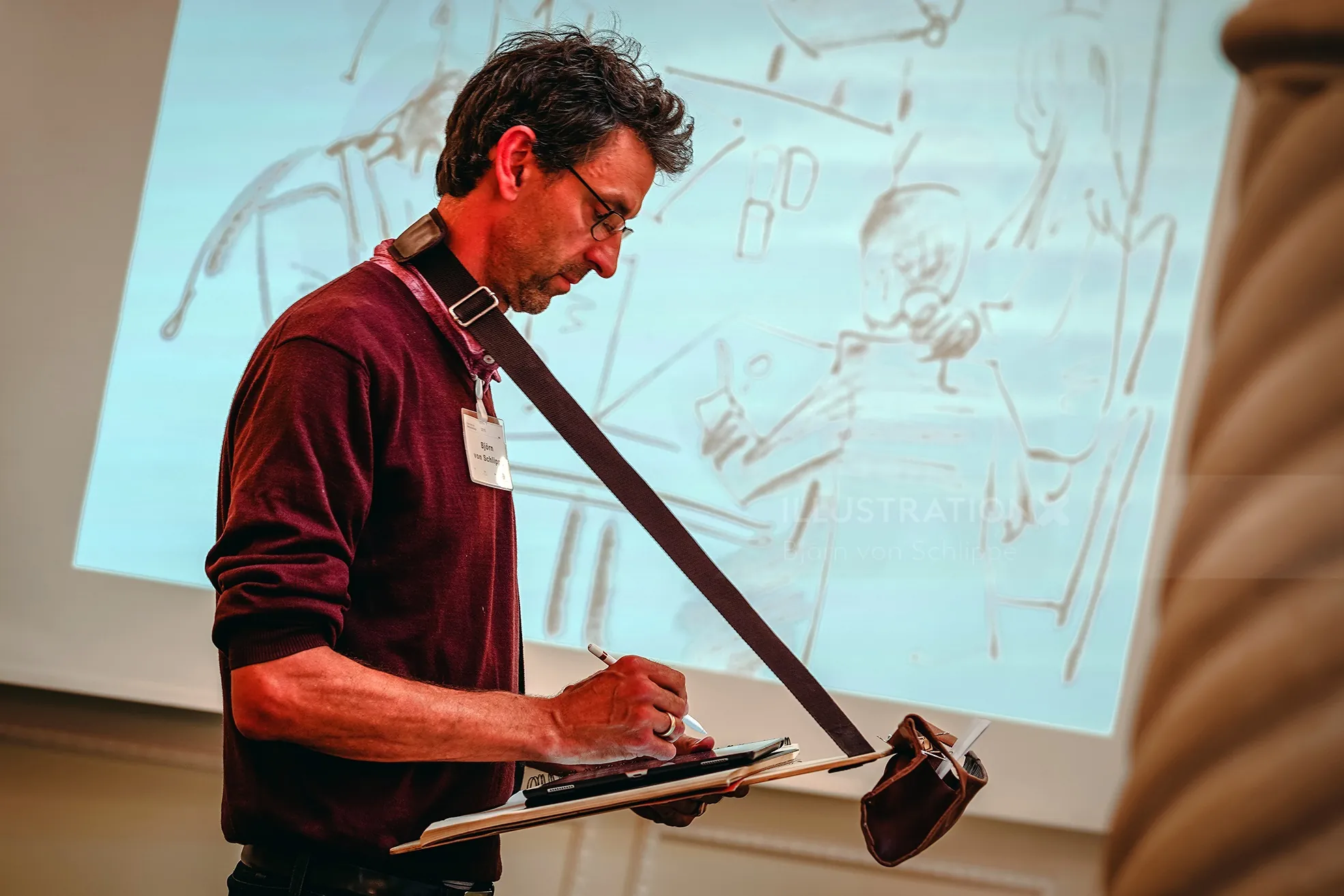 Man sketching on clipboard during art presentation by Björn von Schlippe