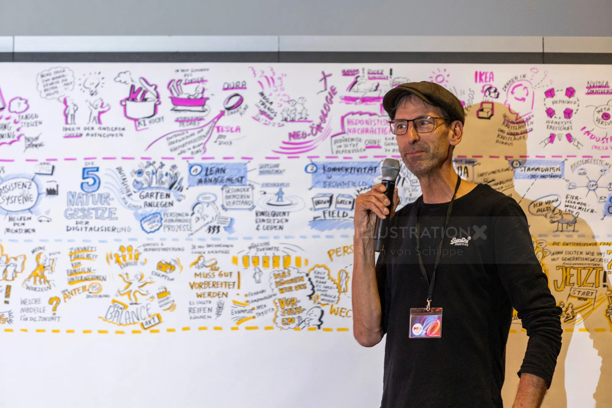 Man with microphone presenting in front of whiteboard covered with sketches