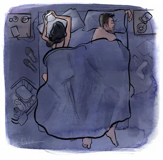 Overhead view of couple in bed, one using phone, by Briana Kranz