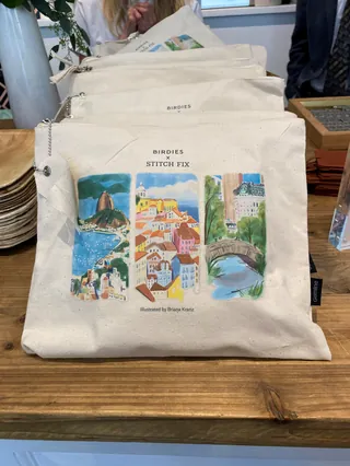 Tote bag with three colorful landscape illustrations on display