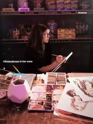Artist Briana Kranz drawing with colored pencils at a live event