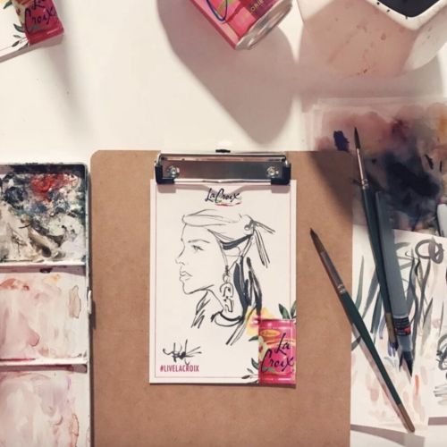 Line drawing of a woman with paintbrushes and drink cans by Briana Kranz