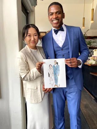 Man in blue suit and woman in white holding fashion illustration by Briana Kranz