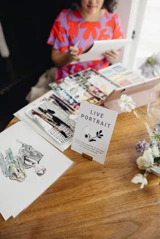 Live portrait drawing setup with sketches by artist Briana Kranz