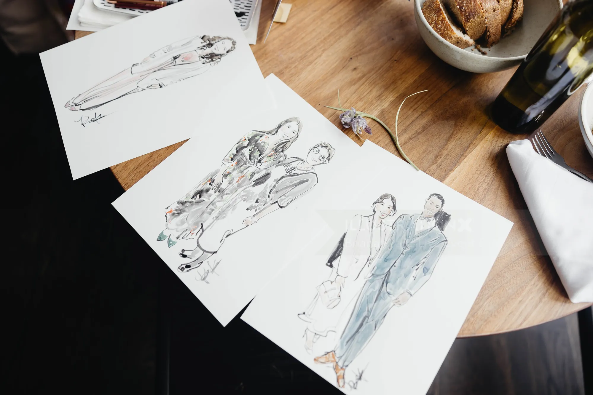 Three detailed fashion sketches on paper on a wooden table by Briana Kranz Live Event Drawing