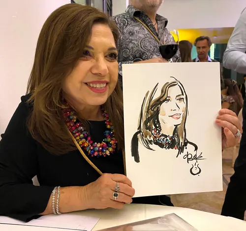 Woman smiling and holding a portrait sketch of herself