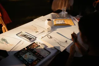Wedding portraits and sketches displayed on a table with warm lighting