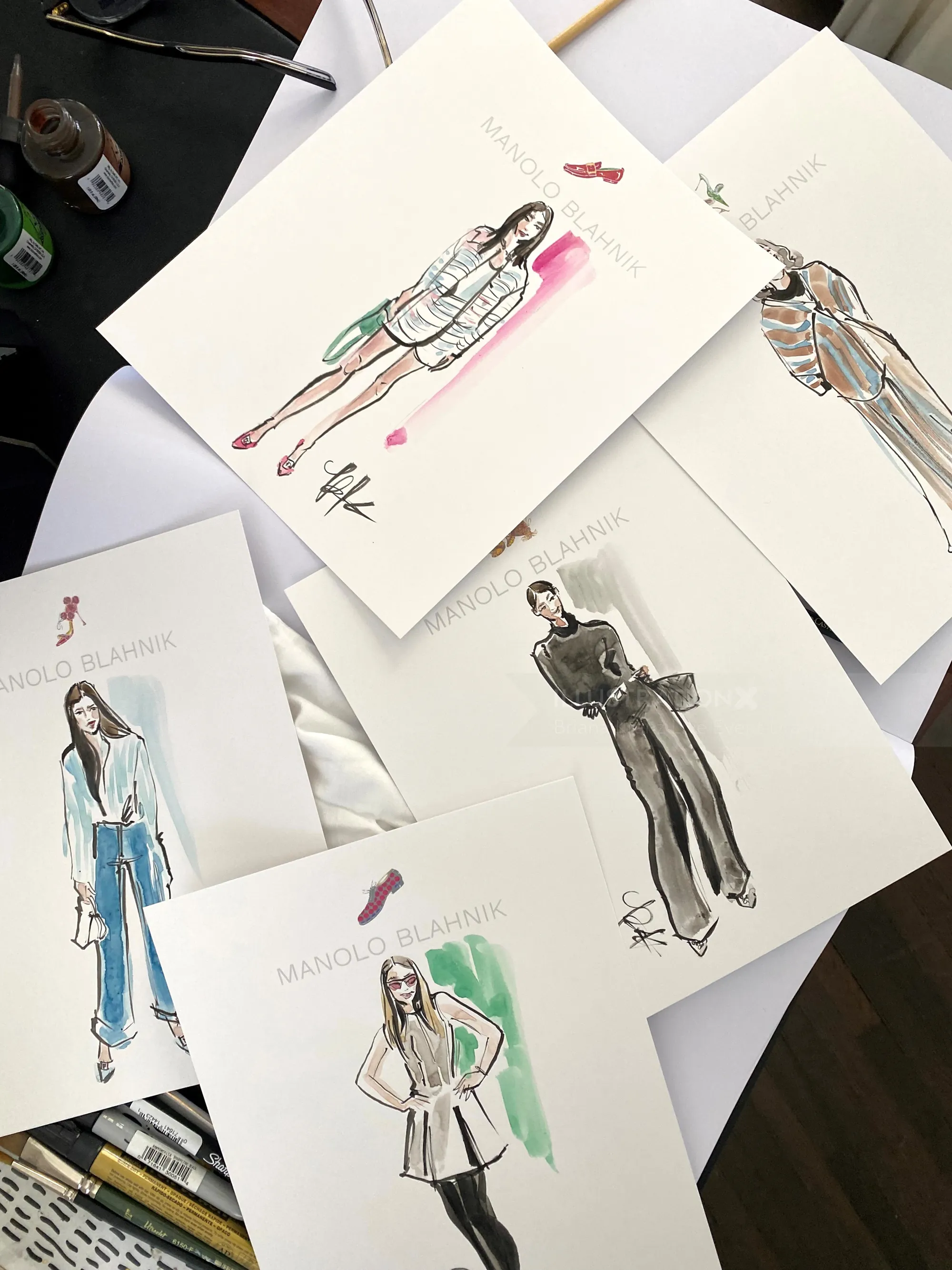 Fashion sketches of models wearing various outfit designs on paper