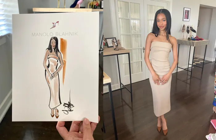 Woman in beige dress standing beside a designer fashion sketch.