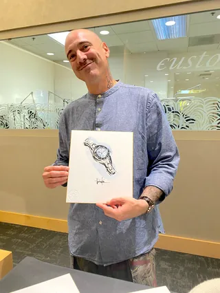 Man smiling and holding a wristwatch sketch