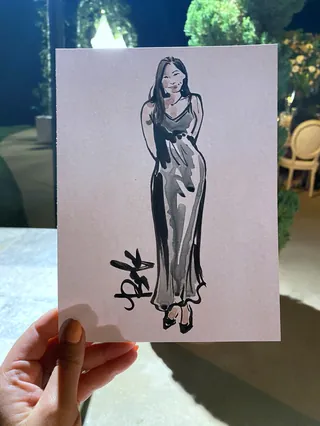 Ink sketch of a woman in a long dress held by hand