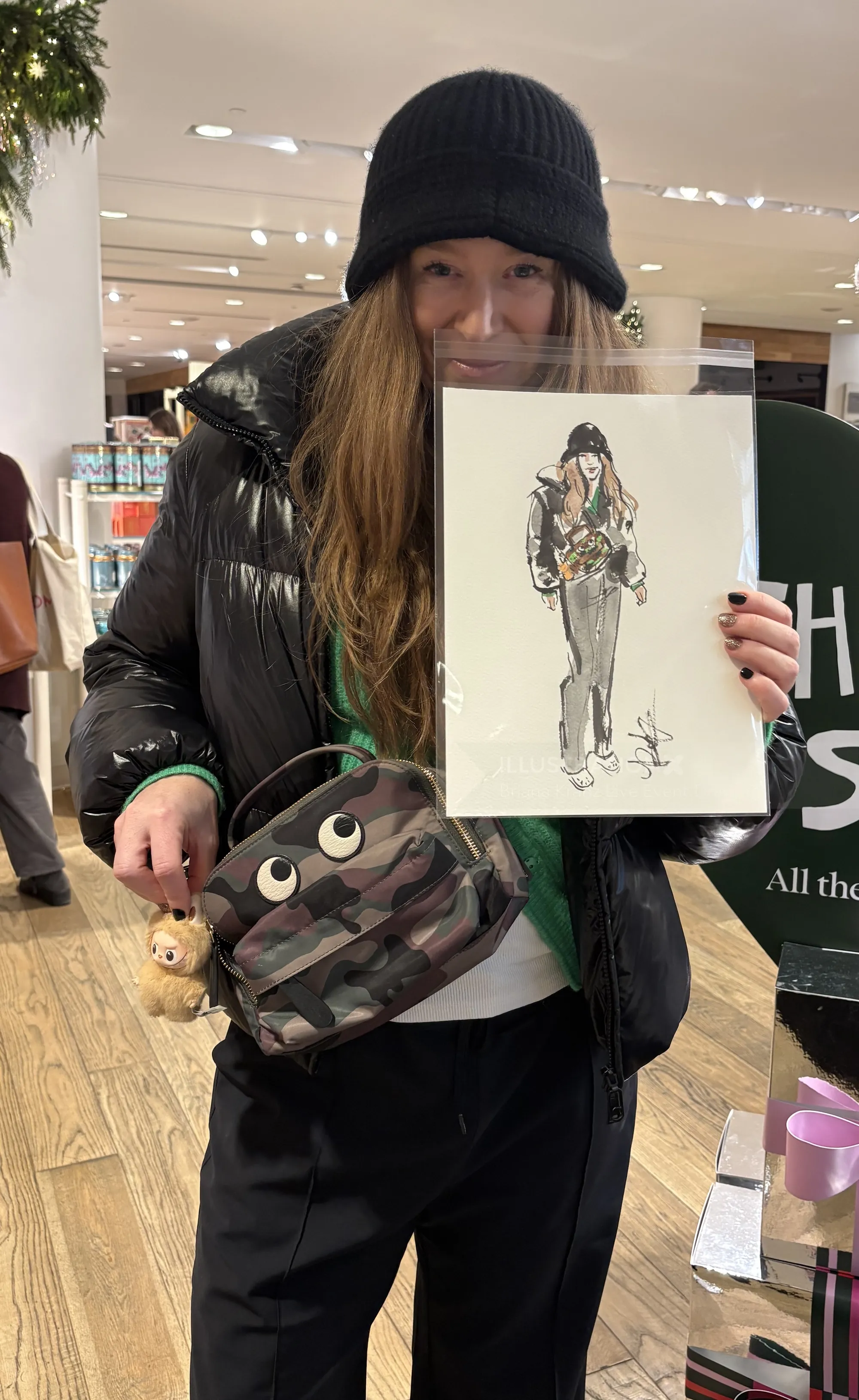 Person wearing black hat and jacket holding fashion sketch by Briana Kranz