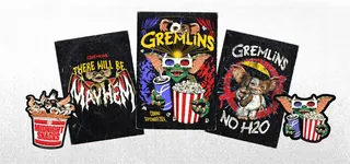 Three Gremlins movie posters with popcorn and Gremlin pins displayed