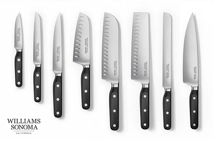 Eight stainless steel kitchen knives with black handles by CUBE