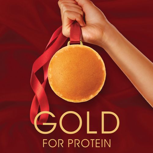 Hand holding a pancake medal with a red ribbon against red background