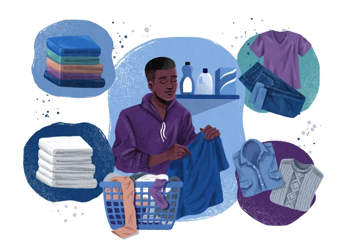 Man folding clothes surrounded by laundry items and clothing stacks