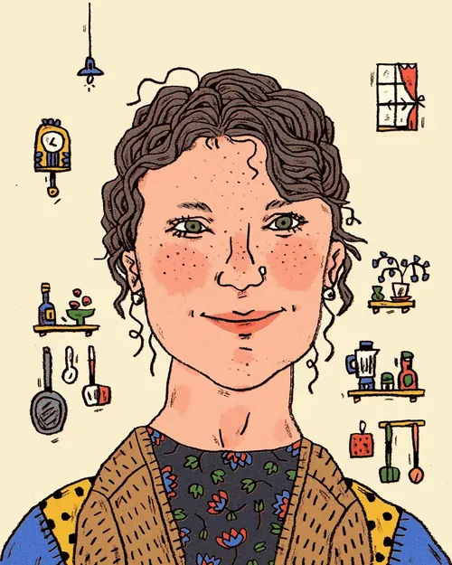 Smiling woman with curly hair in a kitchen surrounded by utensils and plants