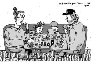 Family of four sitting around diner table eating and talking.