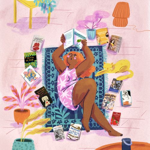 Person relaxing surrounded by books on a patterned rug