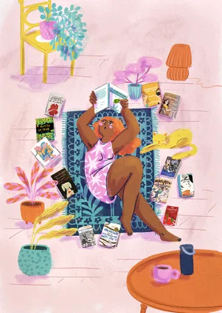 Person relaxing surrounded by books on a patterned rug