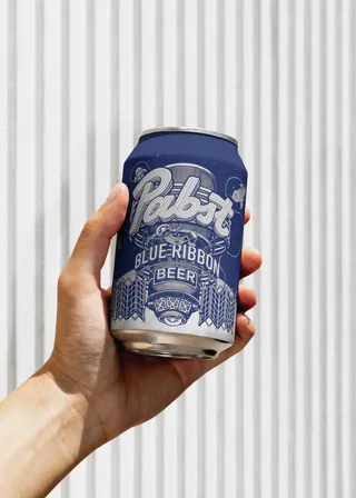 Hand holding a can of Pabst Blue Ribbon beer