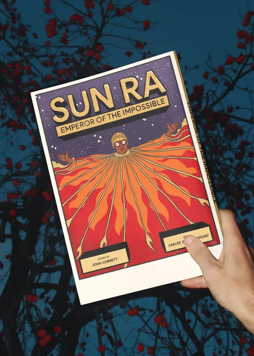 Hand holds Sun Ra Emperor of the Impossible poster with fiery design