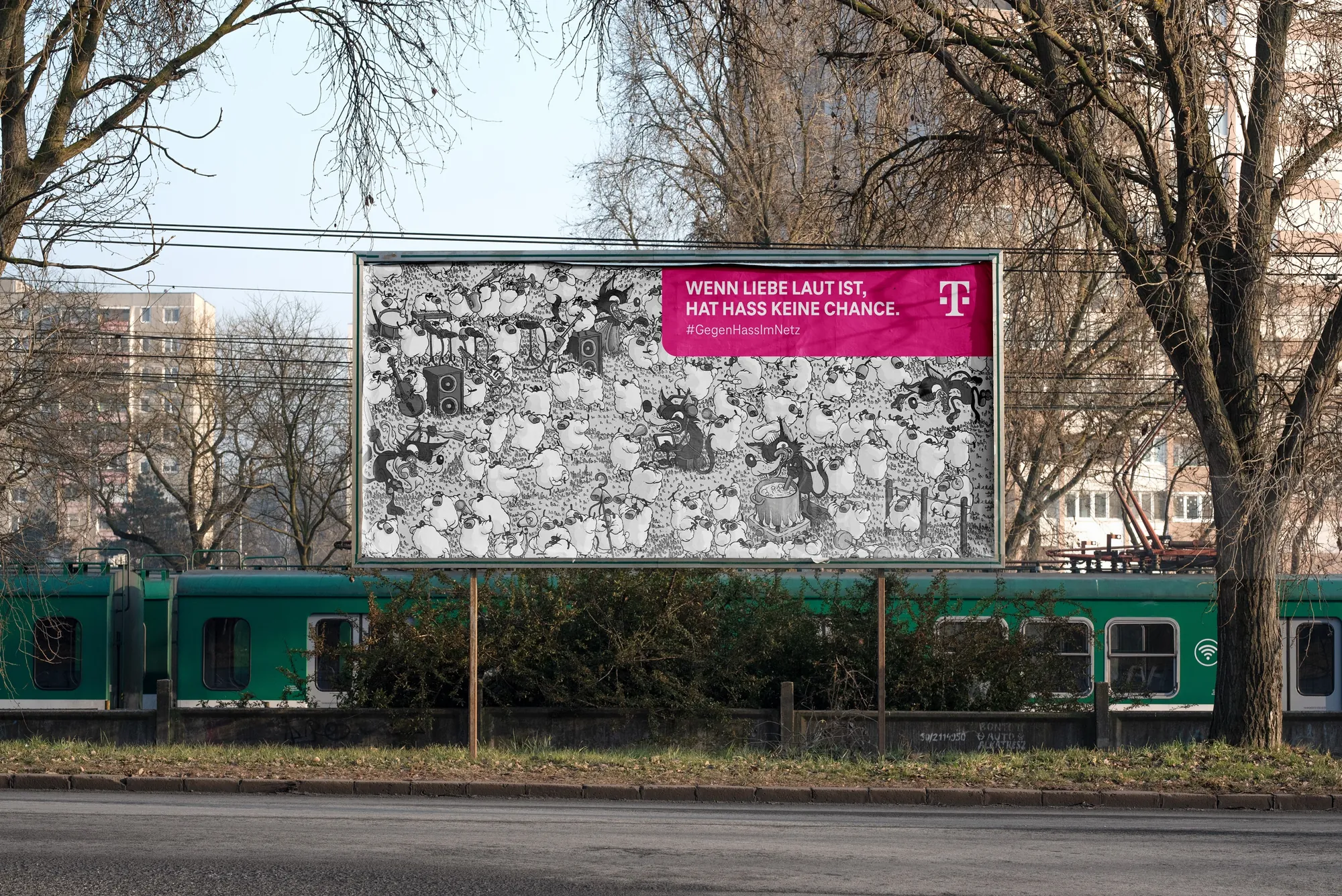 Billboard with German text above green train and bare trees outdoors