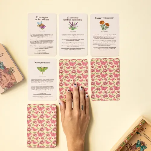 Tarot cards with floral patterns and Spanish text, hand included, by Carolina Zambrano