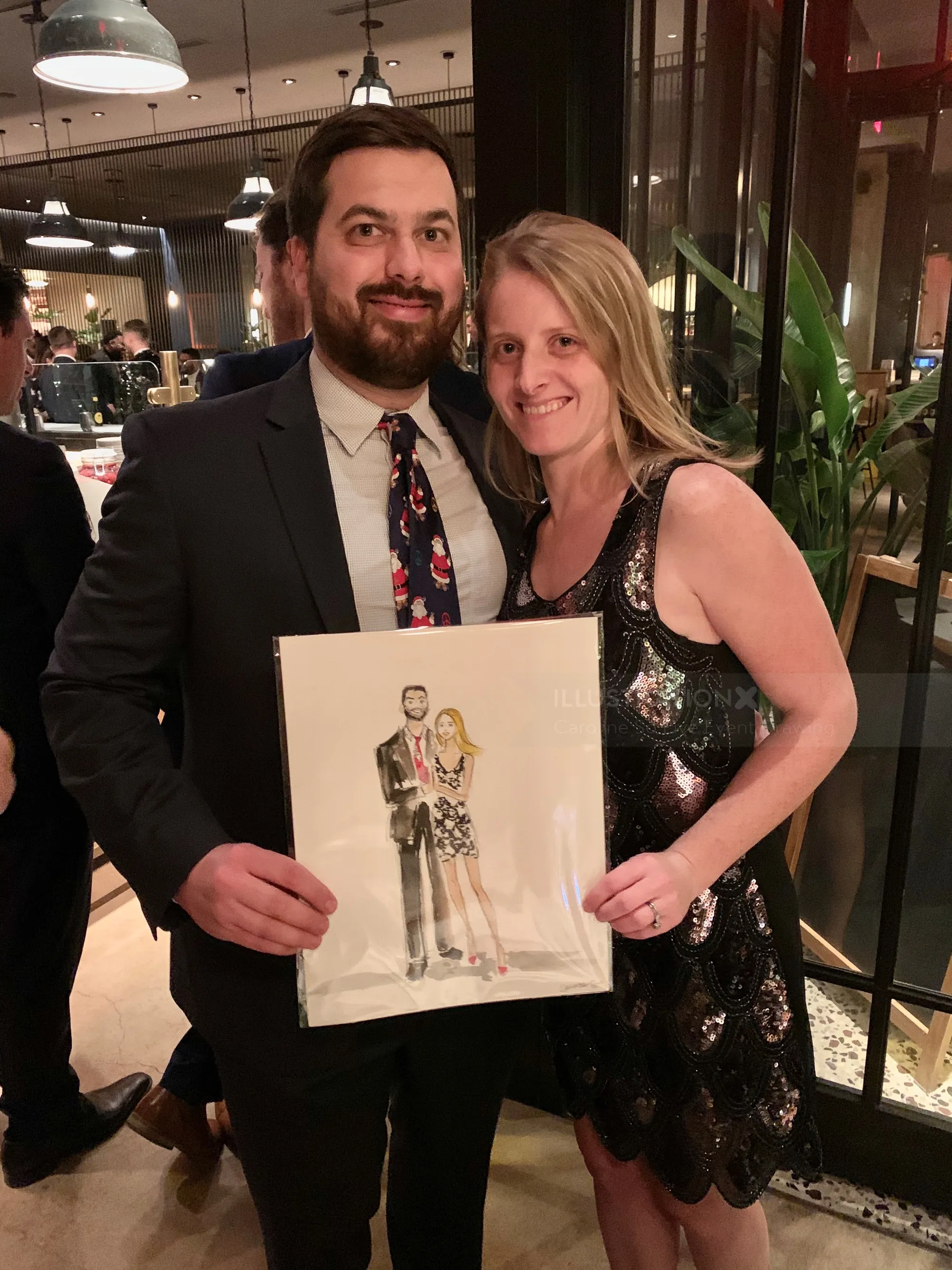 Man and woman in formal attire holding caricature portrait by Caroline So Live Event Drawing