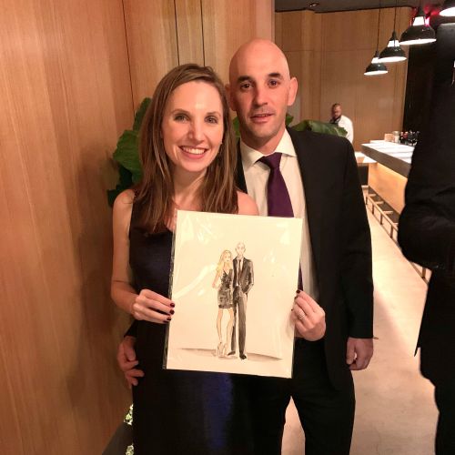 Couple holding caricature drawing by Caroline So in formal attire