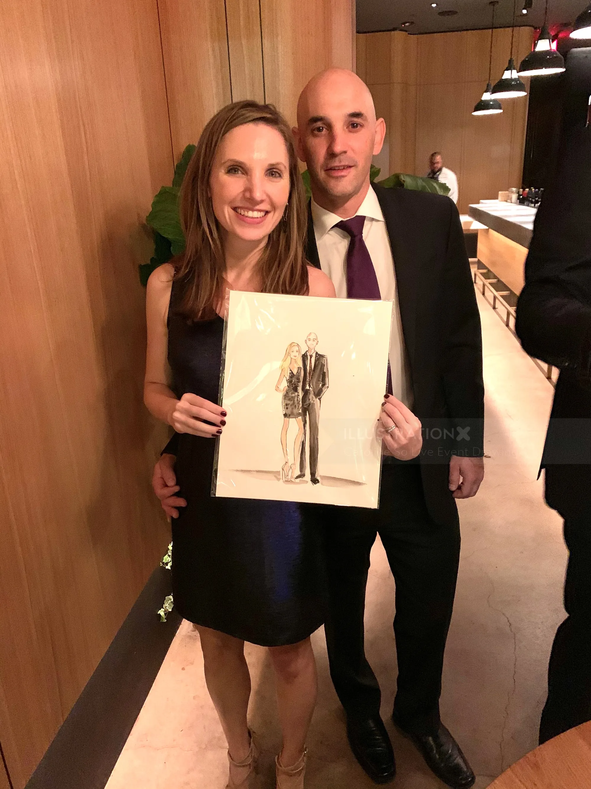 Couple holding caricature drawing by Caroline So in formal attire