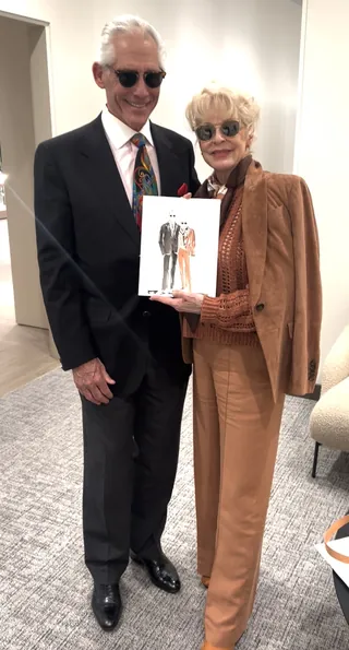 Elderly man and woman in stylish outfits holding a fashion illustration