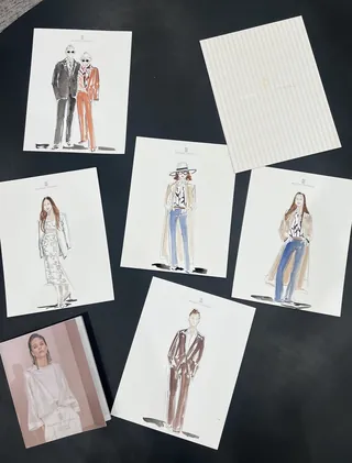 Fashion design sketches and a female model photo laid out on a black background
