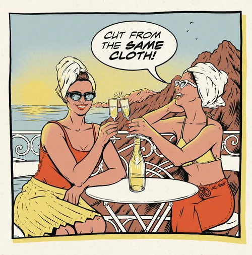 Two women with towels on heads toasting with champagne by ocean at sunset by Cat Sims
