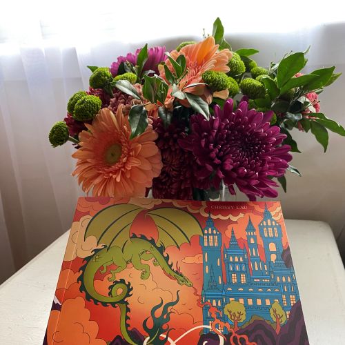 Chrissy Lau's Romantasy Colouring Book beneath a colorful bouquet of flowers