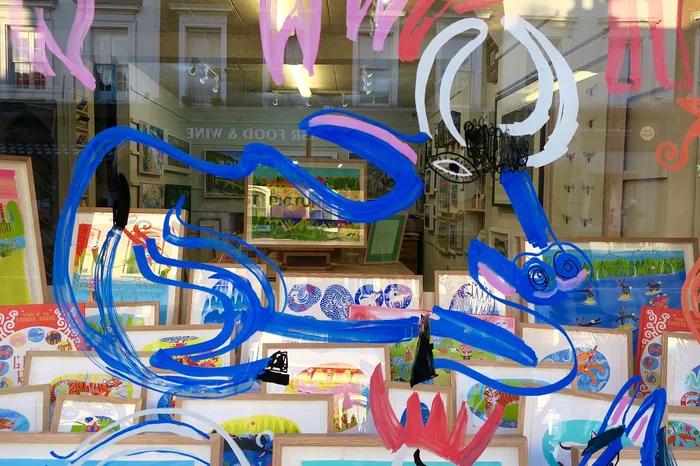 Abstract blue and pink animal painted on a storefront window