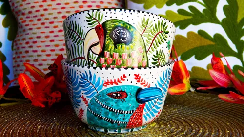 Bols en céramique Coty Borio ornés de motifs colorés d'oiseaux tropicaux, de poissons et de plantes.