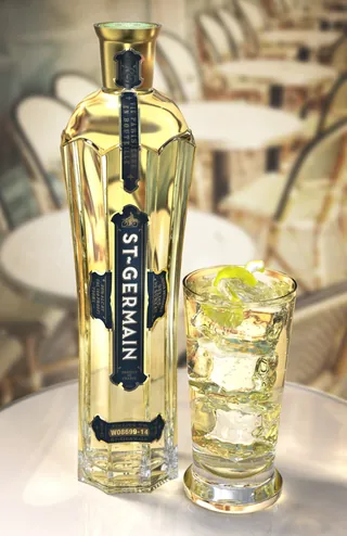 Bottle of St-Germain liqueur and a glass with ice and lemon