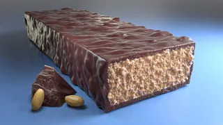 Chocolate coated protein bar with peanuts on blue surface