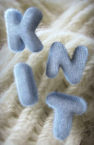 Soft fabric letters K, N, I, T on a knitted background