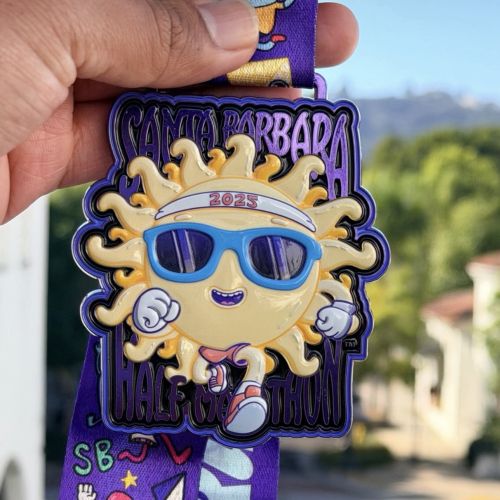 Santa Barbara Half Marathon medal featuring sun character with sunglasses by Daniel Sulzberg
