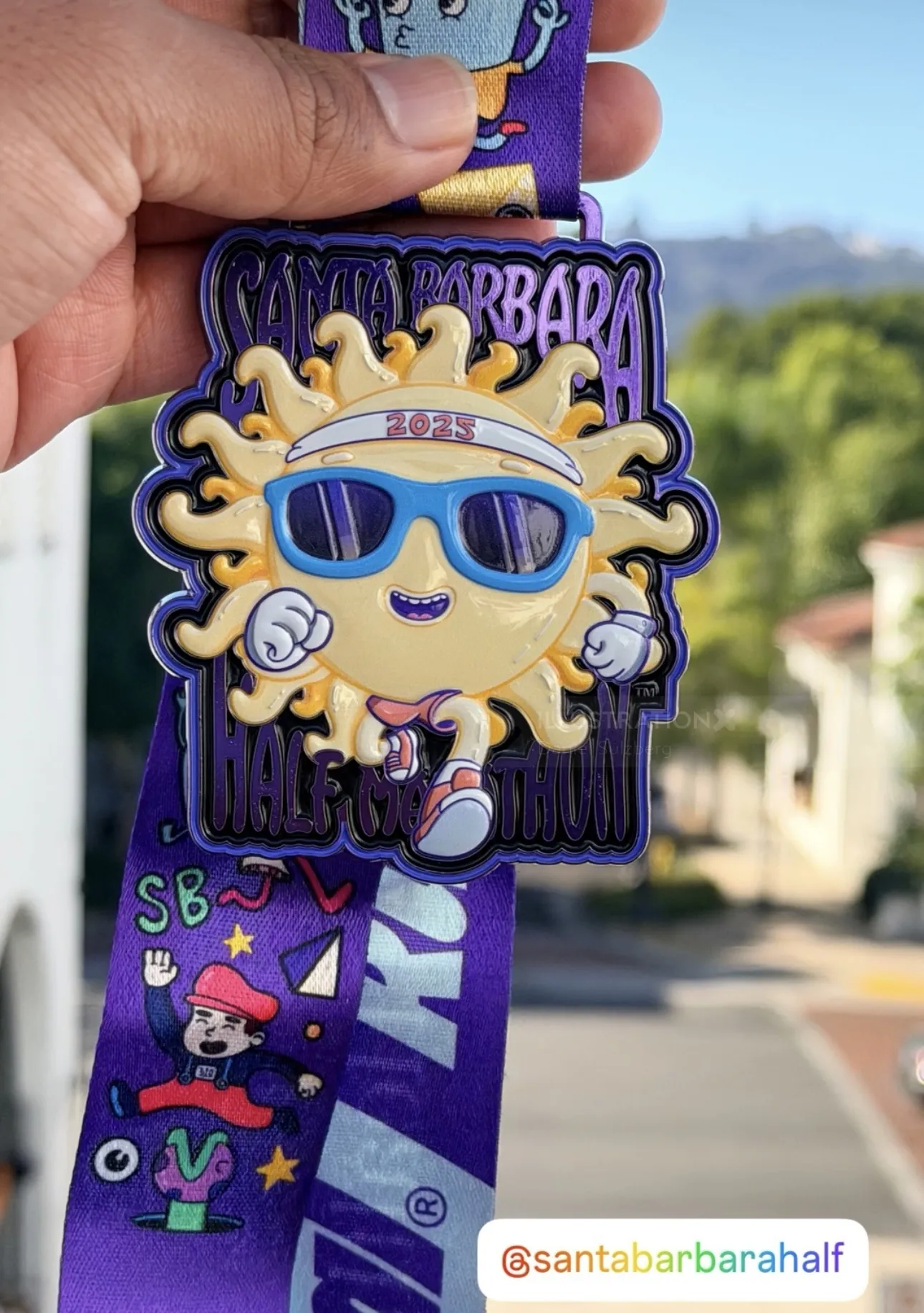 Santa Barbara Half Marathon medal featuring sun character with sunglasses by Daniel Sulzberg