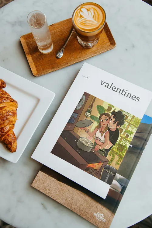 Valentines book with coffee and croissant on a marble table by Danielle Pioli