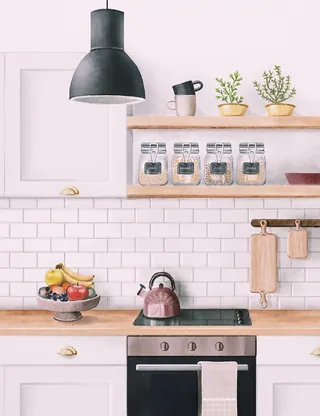 Minimalist kitchen with wooden shelves, glass jars, fruit bowl, and stovetop, by Debora Islas