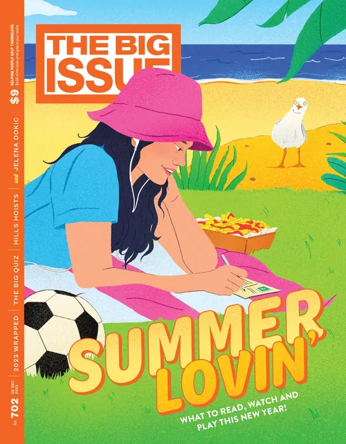 Woman writing on paper at beach with soccer ball and bird nearby