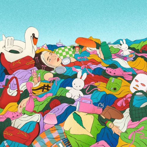 Person resting in a colorful pile of clothes and toys outdoors