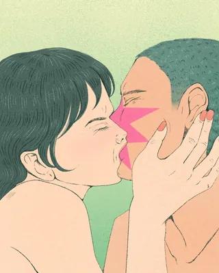 Two people sharing an intimate kiss with colorful face paint.