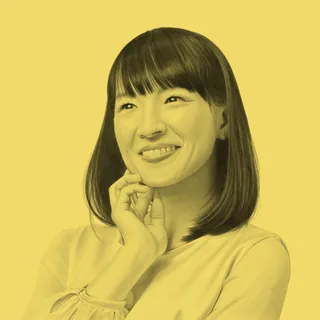 Portrait of Marie Kondo smiling with hand near chin by Dena Cooper